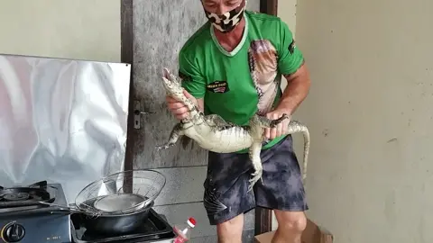 A large monitor lizard has a surprising encounter with a small fluffy pet dog